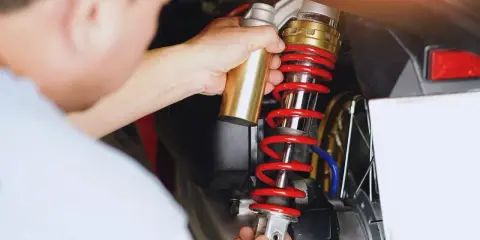 Mechanik wymienia amortyzator w skuterze. Sprawdź wymiana amortyzatorów cena i dowiedz się, ile kosztuje serwis.
