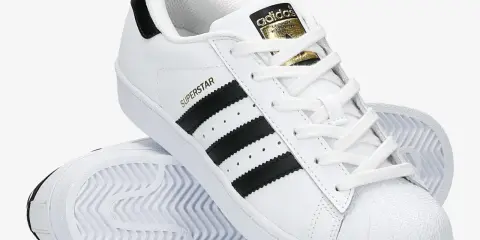 Białe adidas Superstar z czarnymi paskami i złotym logo. Poznaj, czym się różnią modele.