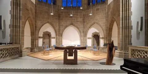 Innenraum der Christuskirche Detmold mit Altar, Stühlen und einem Flügel.
