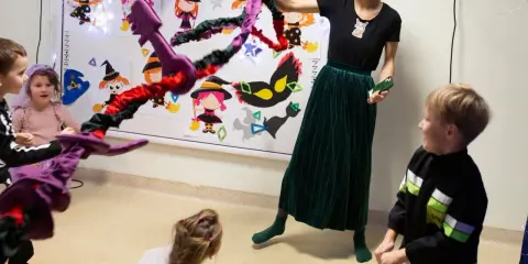 Wesołe zabawy integracyjne z czarownicami i magicznymi kluczami. Dzieci i nauczycielka bawią się w Halloweenowe gry.