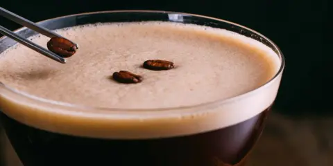 Ein Espresso-Martini, ein köstlicher Kaffee mit Schuss, wird mit Kaffeebohnen garniert.
