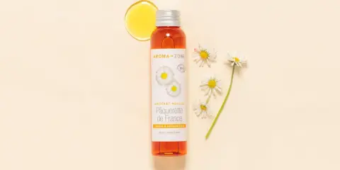 Flacon d'huile de pâquerette Aroma-Zone, avec des pâquerettes. Attention, l'huile de pâquerette danger potentiel pour certaines peaux.