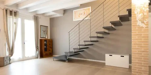 Moderna scala a sbalzo, con gradini scuri e corrimano in metallo. Soluzioni per chi cerca un design audace.