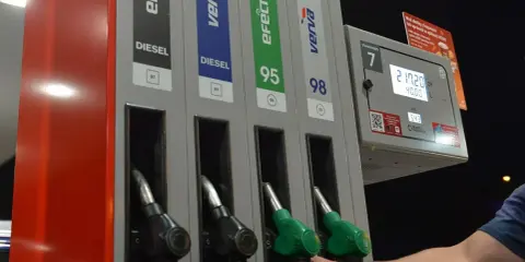 Dłoń sięga po dystrybutor z napisem "verva diesel" na stacji paliw. Obok widnieją inne rodzaje paliwa.