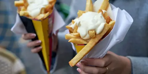 Dwie porcje chrupiących frytek w rożkach, polane obficie kremowymi sosami. Idealne na szybką przekąskę!
