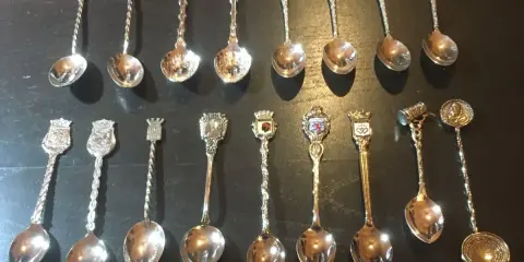 Collection de petites cuillères décoratives, chacune ornée d'un blason ou d'un symbole, révélant la valeur des petites cuillères de collection.