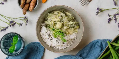 Zielony curry z fasolką szparagową i ryżem, idealne do diety 3000 kcal. Obok świeży imbir i napój z miętą.