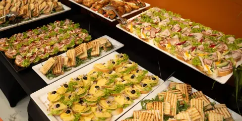 Nowoczesne potrawy wielkanocne: kolorowe kanapki, tosty i croissanty z serem, wędliną i warzywami tworzą apetyczny bufet.