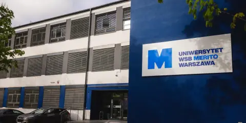 Nowoczesny budynek Uniwersytetu WSB Merito Warszawa z niebieskim logo.