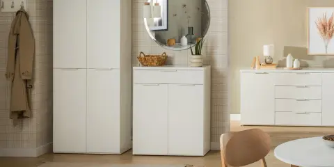 Nowoczesny przedpokój z tapetą w kratę, białe meble, lustro i płaszcz na wieszaku.