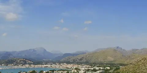 Vista panoramica del porto di Maiorca con montagne sullo sfondo e un mare pieno di barche.