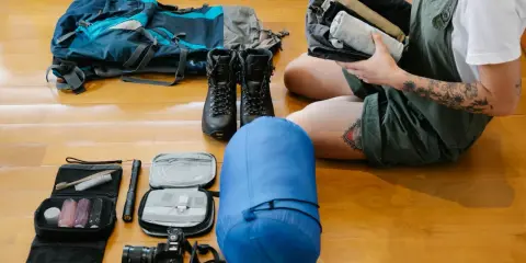 Plecak, buty, śpiwór, aparat i kosmetyczka – wszystko gotowe na wyprawę. Niezbędne gadżety pod namiot czekają na przygodę.