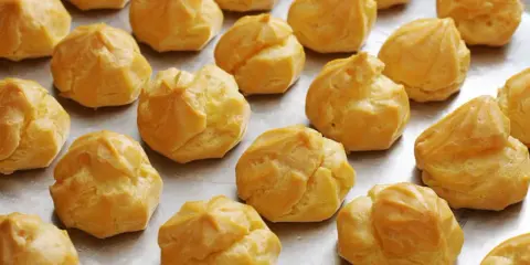 Une fournée de **meilleur choux à la crème** dorés et prêts à être garnir. Parfait pour un dessert gourmand.