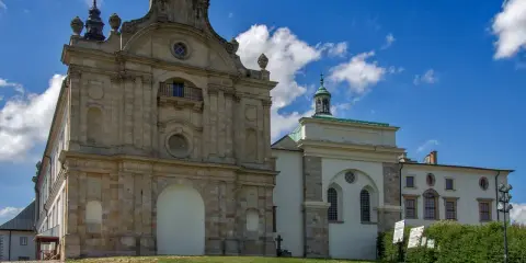 Barokowy zespół klasztorny na Świętym Krzyżu na Łysej Górze, z charakterystyczną architekturą i błękitnym niebem.