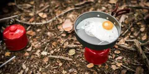 Stekt ägg i stekpanna på campingkök. Enkel och bra vandringsmat som ger energi för äventyret.