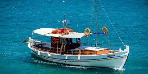 Bateau blanc naviguant sur mer bleue. Le test VHF marine est en cours, tout est prêt pour la traversée.