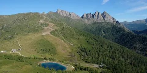 Panorami alpini con sentieri per passeggiate facili vicino a Trento, un lago azzurro e cime rocciose.