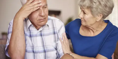 Donna conforta uomo con demenza senile, preoccupato per problemi di defecazione.