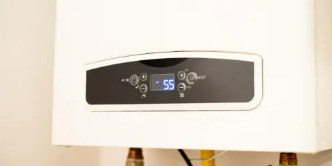 Panel de control de un calentador de gas butano, mostrando la temperatura actual de 55 grados.