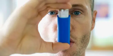 Mann mit Inhalator, bereit gegen **Asthma und Hitze** vorzugehen.