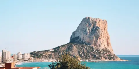 Imponujący klif Peñón de Ifach, jedna z głównych atrakcji Costa Blanca, góruje nad turkusowym morzem i nadmorskim miasteczkiem.