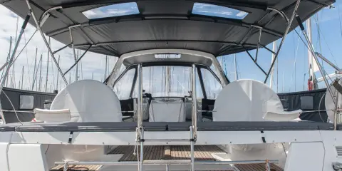 Le taud de bateau, prêt à être refait, protège les deux barres à roue sous un ciel bleu.
