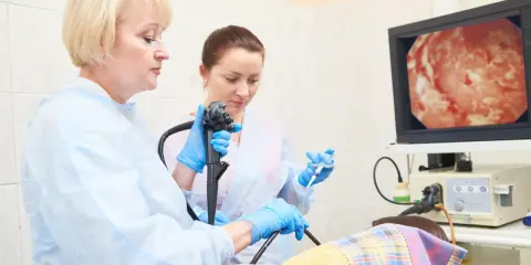 Lekarze wykonują gastroskopię, badanie wnętrza żołądka, obserwując obraz na monitorze.
