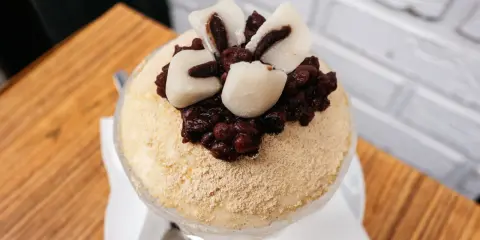 Puszysty deser lodowy posypany mąką sojową, z fasolką adzuki i kluskami mochi. Inspiracja koreańskimi przepisami na ciasta.