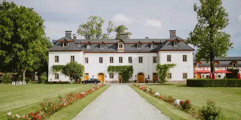 Piękna dolina pałaców i ogrodów z białym budynkiem, zielonym trawnikiem i kwitnącymi kwiatami.