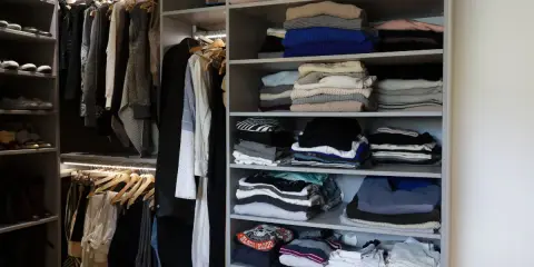 Un dressing bien organisé : vêtements pliés et suspendus, chaussures rangées. Idéal pour savoir comment organiser son dressing.