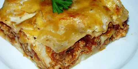 Pyszna lazania Ani gotuje się w piekarniku, tworząc apetyczne warstwy makaronu, mięsa i sera.