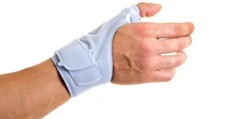 Dłoń z niebieskim stabilizatorem na kciuk, który pomaga w leczeniu przeprostu kciuka.