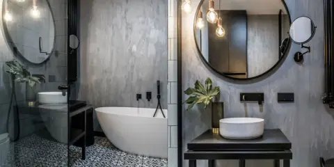 Nowoczesna łazienka w stylu loft z wolnostojącą wanną, umywalką nablatową i betonową ścianą.