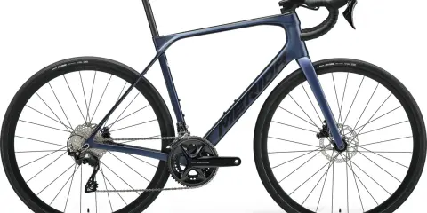 Granatowy rower szosowy endurance z hamulcami tarczowymi i napędem Shimano 105. Idealny na długie trasy.