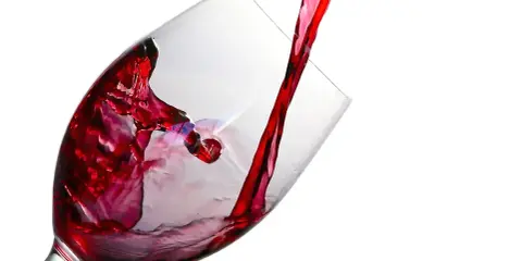 Czerwone wino leje się do kieliszka, tworząc wiry. Ile promili w lampce?