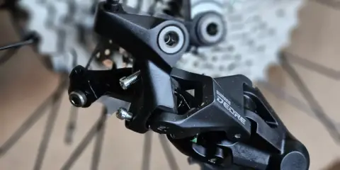 Precyzyjne mocowanie tylnej przerzutki Shimano Deore, gotowe do montażu na rowerze.