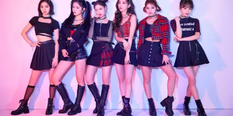 Sex k-pop-inspirerade tjejer poserar i coola outfits med rutiga kjolar och stövlar.
