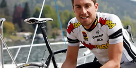 Bernie Eisel, Radsportler, lächelt neben seinem Rennrad auf einem Boot.