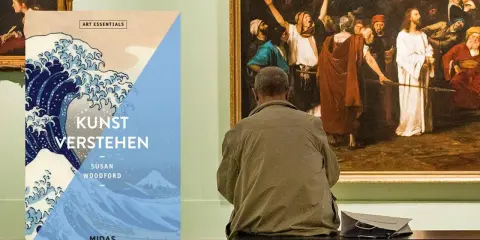 Ein Mann betrachtet ein Gemälde in einer Galerie. Daneben liegt ein Buch mit dem Titel "Kunst verstehen", das die moderne Kunst thematisiert.
