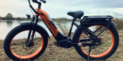 Orange-schwarzes E-Bike mit breiten Reifen am Seeufer. Gute Lankeleisi Erfahrungen sind garantiert mit diesem robusten Fatbike.