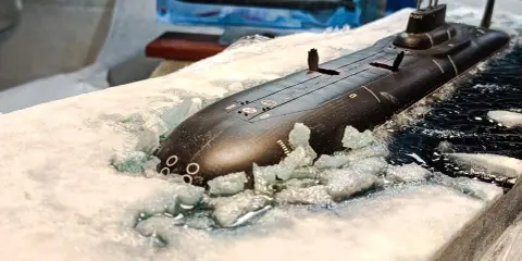 Ein Modell eines U-Bootes Akula bricht durch Eis und Wasser.