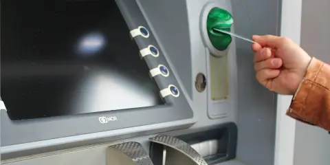 Mano insertando una tarjeta N26 extranjero en un cajero automático.