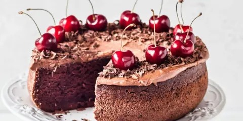 Gâteau chocolat cerise, riche et moelleux, décoré de cerises fraîches et de copeaux de chocolat. Un délice gourmand.