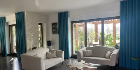 Jasne, turkusowe zasłony w salonie dodają mu uroku. Dowiedz się, jak prać zasłony, by zachowały świeżość i kolor.