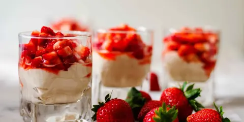 Enkel dessert med jordgubbar i glas, toppad med färska jordgubbar och en krämig fyllning. Perfekt för en sommardag.