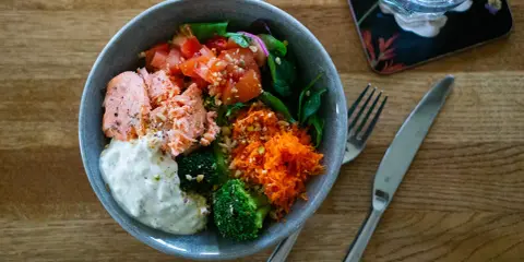 En härlig poke bowl med lax, broccoli, tomat och rivna morötter. Ett perfekt poke bowl recept för en hälsosam lunch.
