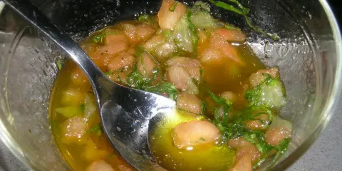 Sauce vierge fraîche avec des dés de tomate, des herbes et de l'huile d'olive, prête à accompagner un poisson.