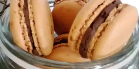 Délicieux macarons à la ganache chocolat, prêts à être dégustés dans un bocal en verre.