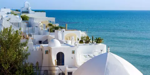 Casas blancas con cúpulas y el mar azul en Túnez. Un lugar perfecto para disfrutar con niños.