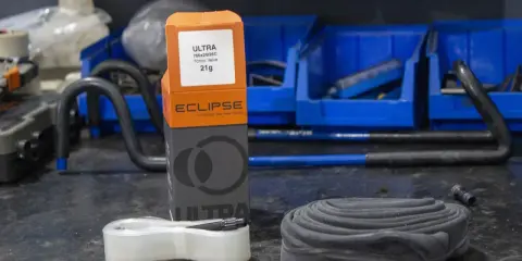 Eclipse Ultralight TPU Schlauch Flicken-Set für Fahrradreifen. Ein neuer, leichter Schlauch liegt neben dem alten, aufgerollten Schlauch.